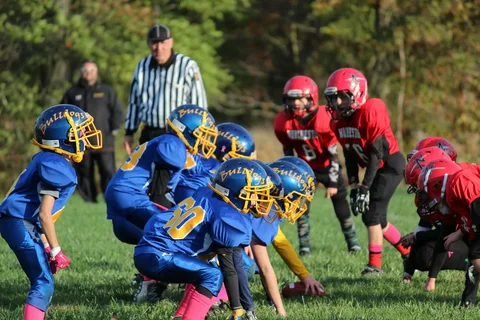 Jugend-Footballteams stehen sich an der Line of Scrimmage gegenüber – Symbol für Teamgeist, Wettkampf und mentale Vorbereitung in Teams und Vereinen.