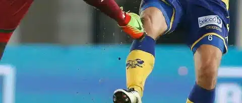 Zweikampf im Fußball mit hartem Foul am Bein eines Spielers – verdeutlicht, wie Mentaltraining nach Sportverletzung hilft, Angst vor neuen Verletzungen abzubauen und Vertrauen zurückzugewinnen.