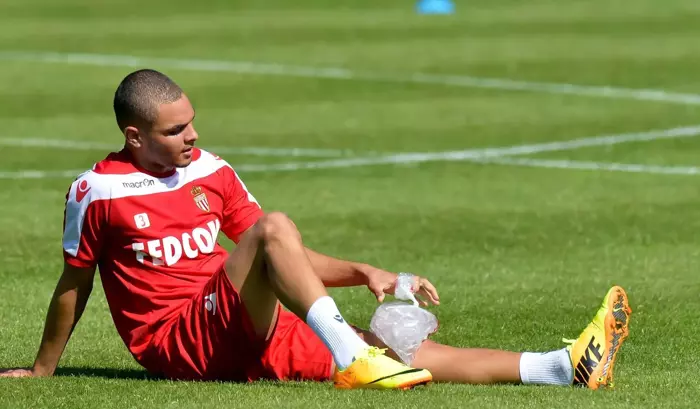 Fußballspieler sitzt mit Eisbeutel auf dem verletzten Knie am Spielfeldrand – Symbol für Mentaltraining nach Sportverletzung, um Vertrauen und Sicherheit für die Rückkehr ins Training aufzubauen.